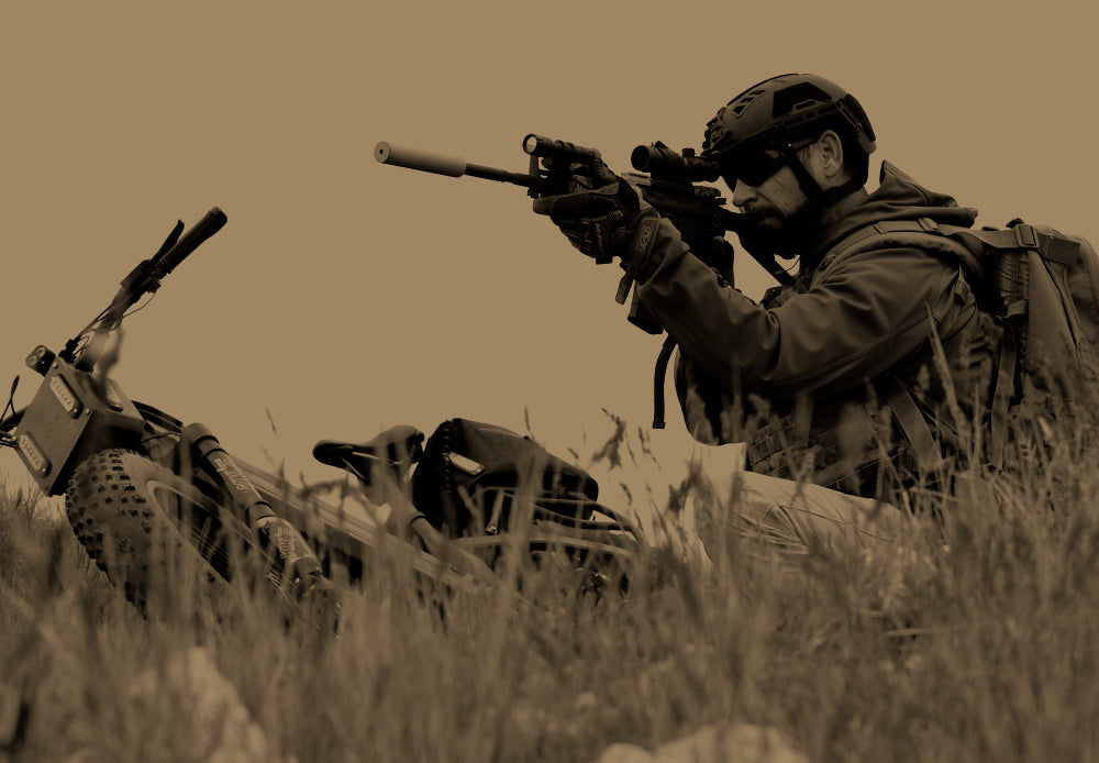 Military man taking aim while crouched over his Bakcou eBike