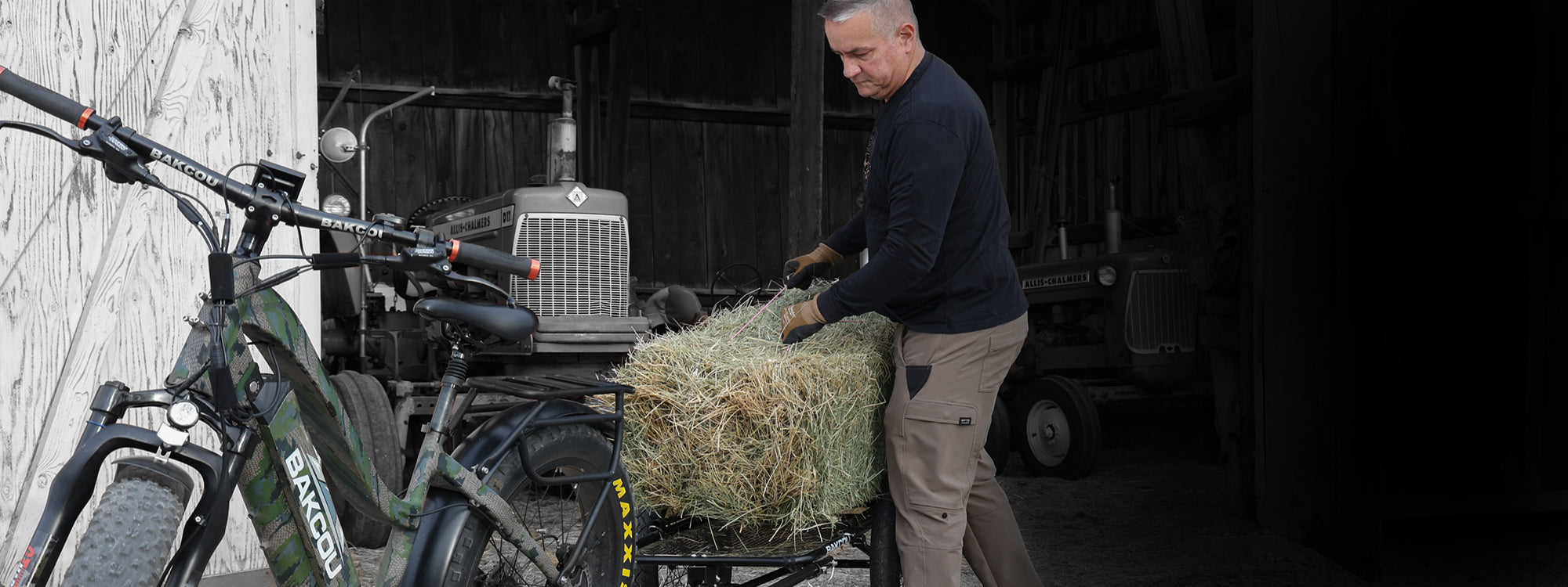 Farmer loading hay on to the back of a trailer attached to a Bakcou Mule eBike